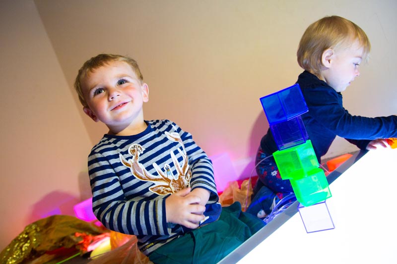 Boy and girl play with coloured cubes