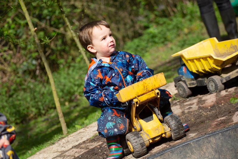 boy plays on yellow digger