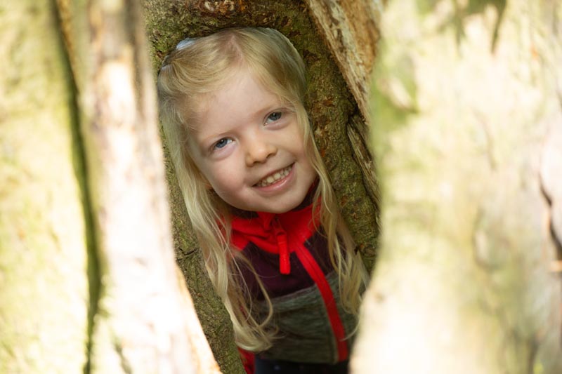 girl hiding in tree