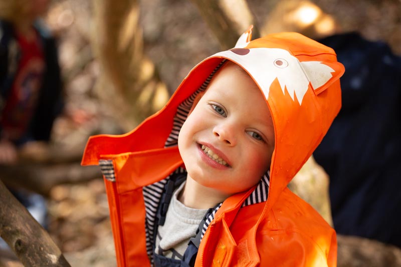 boy in orange rain coat outside